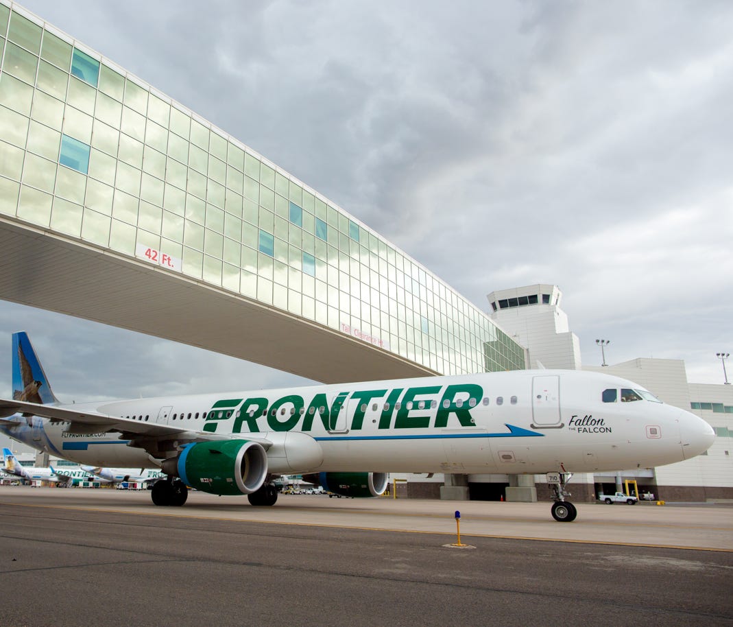 A Frontier Airbus A321 passes under the landmark pedestrian bridge at  Denver International Airport on May 7, 2017.
