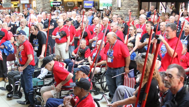 The Honor Flight veterans stand for the National Anthem on Sunday, Sept. 11.