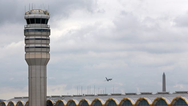An airplane flies between the air traffic control tower and the Washington Monument at Washington's Ronald Reagan National Airport on Monday. For more than three years, the government has kept secret a study it requested that found air traffic controllers’ work schedules often lead to chronic fatigue, making them less alert and endangering the safety of the national air traffic system, according to report on the study obtained by The Associated Press.