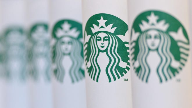 A collection of venti sized Starbucks take away cups.