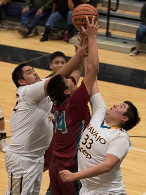 Shiprock's Cota Nahkai battes Navajo Prep's Anthony Pioche-Lee and Tyler Pete for a rebound in the fourth quarter on Friday at the Eagles Nest in Farmington.