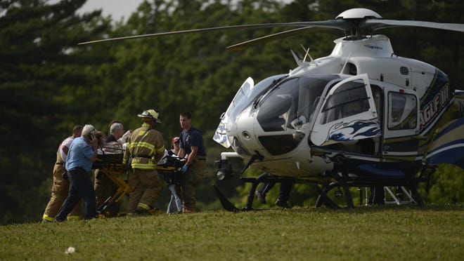 Emergency workers rush a man on a gurney to the Eagle III rescue helicopter Wednesday in Ledgeview. Rescue workers freed the man who was trapped for 90 minutes in a piece of excavation equipment.