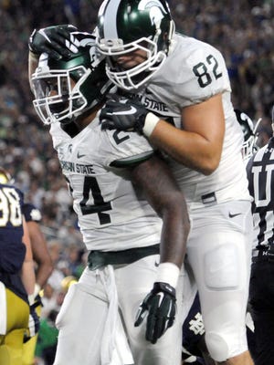 Michigan State University senior tight end Josiah Price (82) jumps on the back of Michigan State University junior running back Gerald Holmes (24) after he scored a touchdown in the second half of the Spartans 36-28 win over Notre Dame Saturday, Sept. 17, 2016 in South Bend, Ind. Holmes finished with 100 yards rushing on 13 carries and two touchdowns.