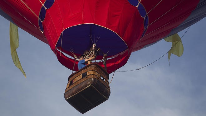 A hot air balloon takes to the sky during the morning launch during Balloon and Rib Fest at the Wausau Downtown Airport, Saturday, July 11, 2015.