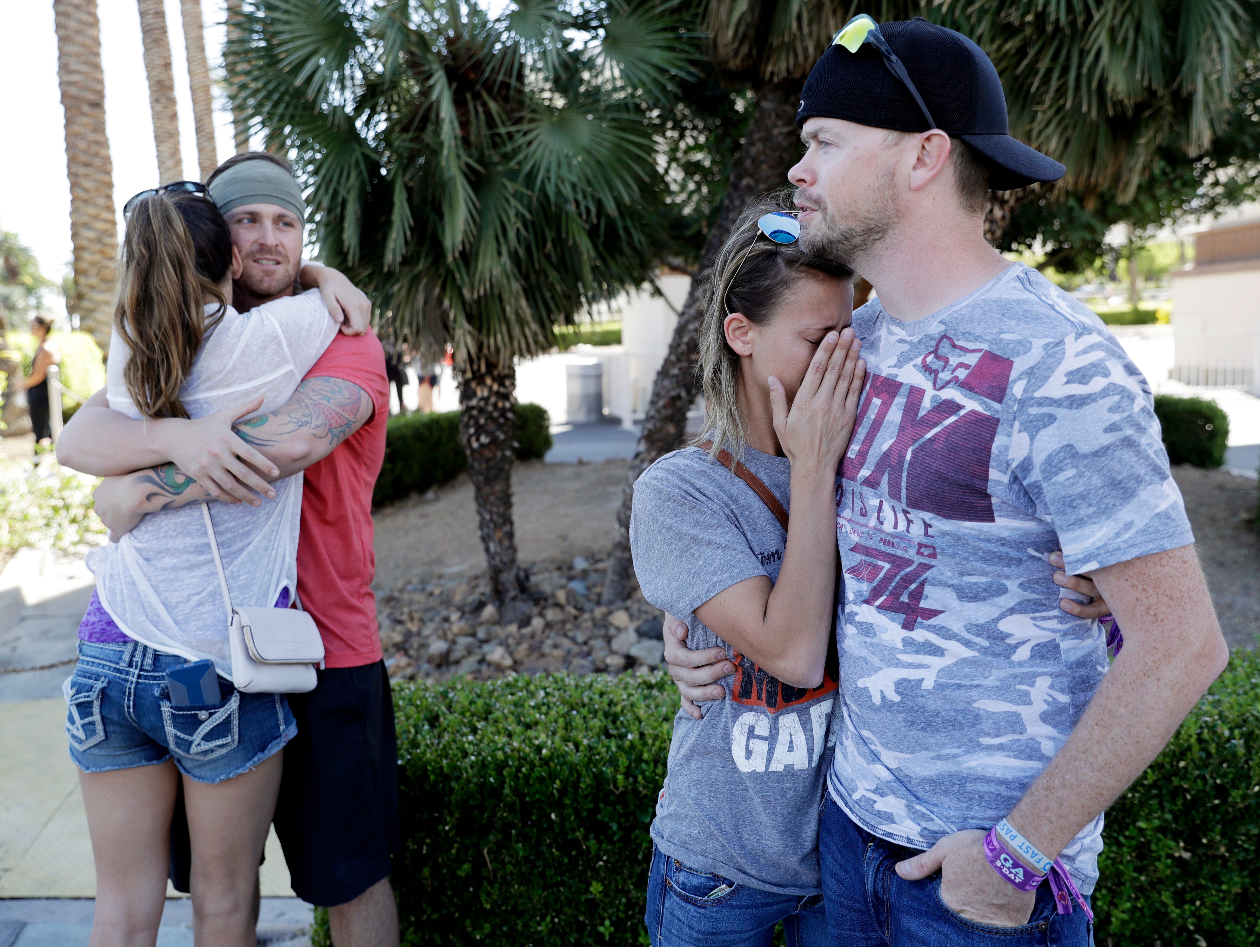 Sean Bean, of Livermore, Calif., hugs his girlfriend, Katie Kavetski, of San Leandro, Calif., left, as Travis Reed, of Mexico, Ind., right, comforts his girlfriend, Anna Travnicek, second from right, on Las Vegas Strip.  All attended the concert wher