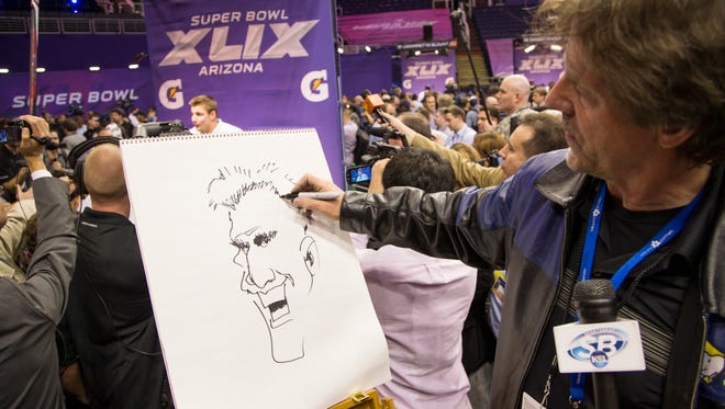 The Arizona Republic editorial cartoonist Steve Benson draws a caricature of New England Patriots TE Rob Gronkowski during Super Bowl Media Day at U.S. Airways Center in Phoenix January 27, 2015. The Patriots will play the Seattle Seahawks Sunday February 1 in Super Bowl XLIX in Glendale.