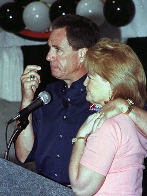 NASCAR driver Darrell Waltrip, left, hugs his wife,