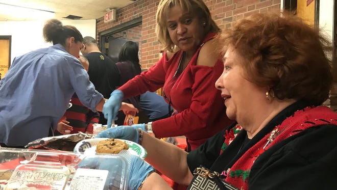 Bloomfield Police records clerks, from left, Ana Rodriguez and Joan Cataldo serve goodies at the Bloomfield Police Department's annual holiday toy driver give-a-way on Thursday, Dec. 21, 2017.
