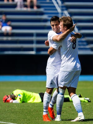 Delaware's Jaime Martinez (No. 8) hugs teammate Guillermo Delgado after Delgado put a shot past Fordham keeper Rashid Nuhu (left) for a goal in the first half of Delaware's 1-0 win over Fordham at Grant Stadium at the University of Delaware on Sunday afternoon.