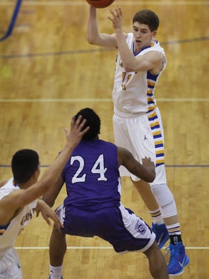 Carmel's Ryan Cline, the game's high-scorer with 32 points, passes off to teammate Sterling Brown over Ben Davis' DeShon Tate in the second half of the Greyhounds' 50-41 win over the Giants at Carmel on Friday, Jan. 30, 2015. The Class 4-A No. 4 Greyhounds upped their record to 14-2 and No. 10 Ben Davis fell to 12-5. 