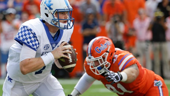 Kentucky quarterback Drew Barker, left, looks for a receiver as he is pressured by Florida defensive lineman Joey Ivie in the first half of an NCAA college football game, Saturday, Sept. 10, 2016, in Gainesville, Fla. (AP Photo/John Raoux)