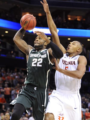 MSU's Branden Dawson goes in for a dunk past Virginia's Darion Atkins during their NCAA tournament game Sunday in Charlotte, N.C. Dawson finished with 15 points, nine rebounds and four blocked shots in the Spartans' 60-54 win.