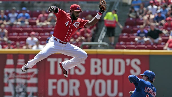 Reds second baseman Brandon Phillips leaps for a throw as Cubs catcher Kyle Schwarber slides safely into second base in the top of the first inning Wednesday afternoon.