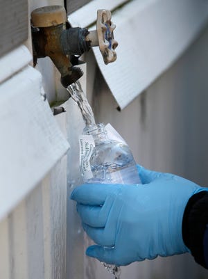 A contractor for the Cabot Oil & Gas Corp. collects a water sample from a resident’s home in Dimock, Pa.  on Feb. 13, 2012