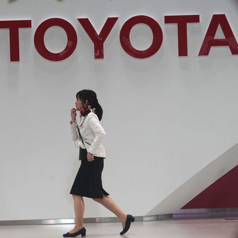 A worker walks past the Toyota logo at a gallery i