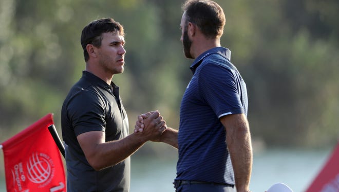 Brooks Koepka, left, shakes hands with Dustin Johnson after finishing the 18th hole in round three of the 2017 WGC-HSBC Champions golf tournament held at the Sheshan International Golf Club in Shanghai, China,  Oct. 28.