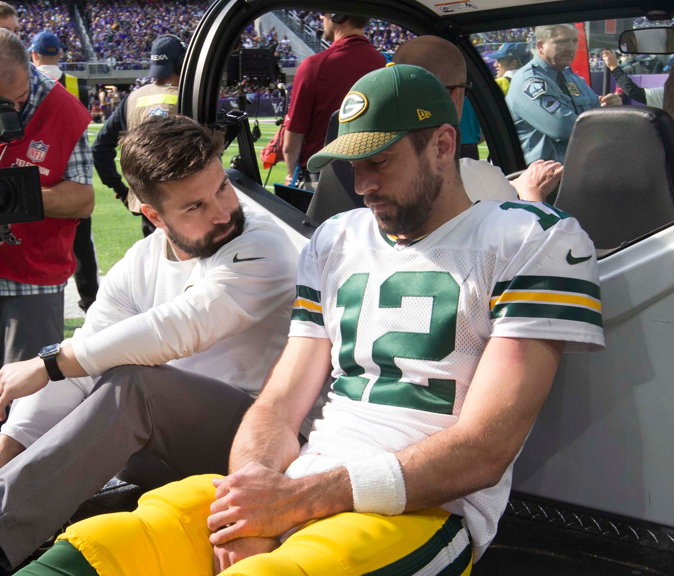 Packers QB Aaron Rodgers is carted off the field in Minneapolis on Sunday.