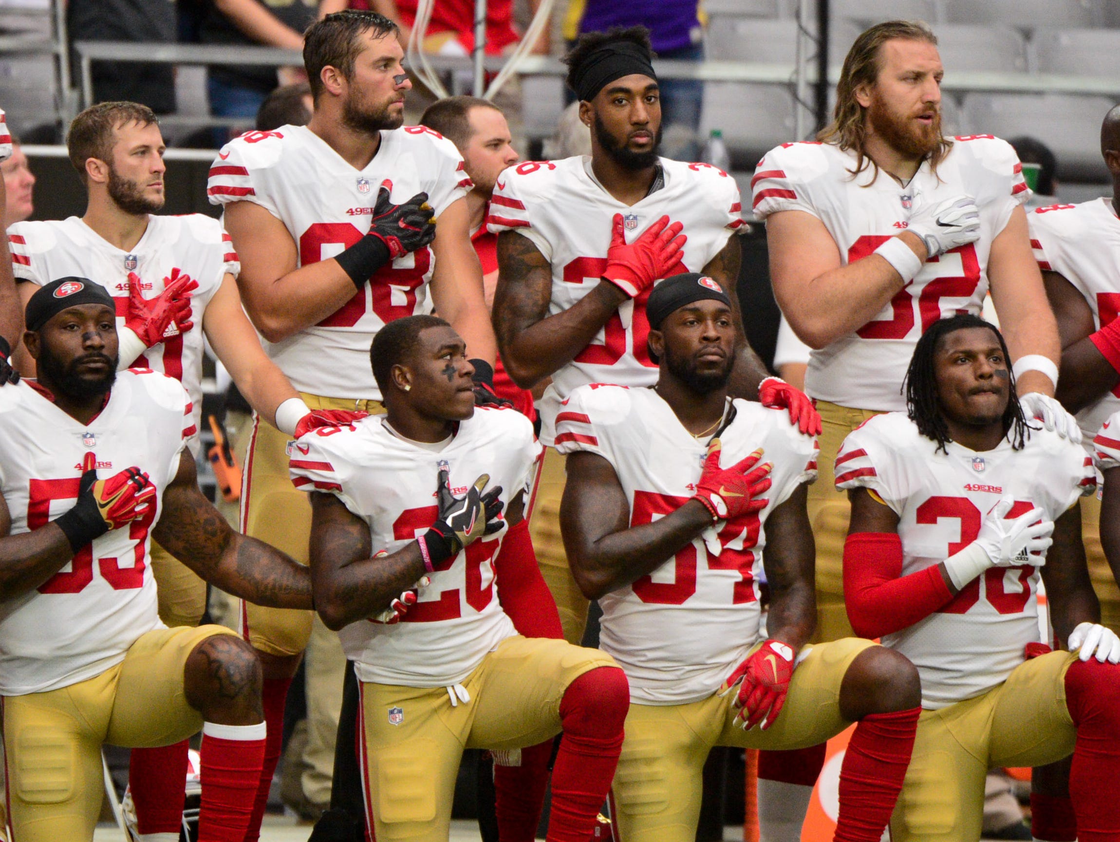 Members of the San Francisco 49ers kneel during the National Anthem prior to a game against the Arizona Cardinals at University of Phoenix Stadium.