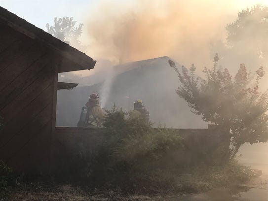 Redding firefighters try to knock down a fire at one