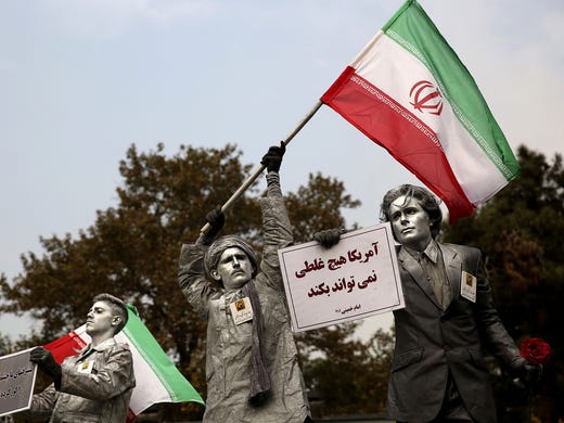 Iranian artists demonstrate against the USA. The posters read, merica cannot do a damn thing."