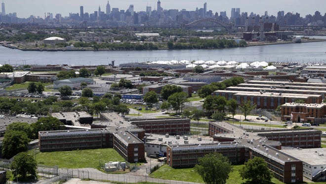 FILE - In a June 20, 2014, file photo, the Rikers Island jail complex stands in New York with the Manhattan skyline in the background. The nationâs jails and prisons are on high alert about the prospect of the new coronavirus spreading through their vast inmate populations. (AP Photo/Seth Wenig, File)