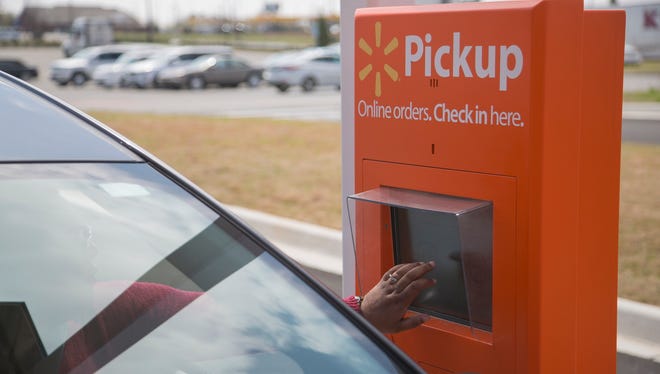A Walmart customer uses the kiosk for online grocery pickup.