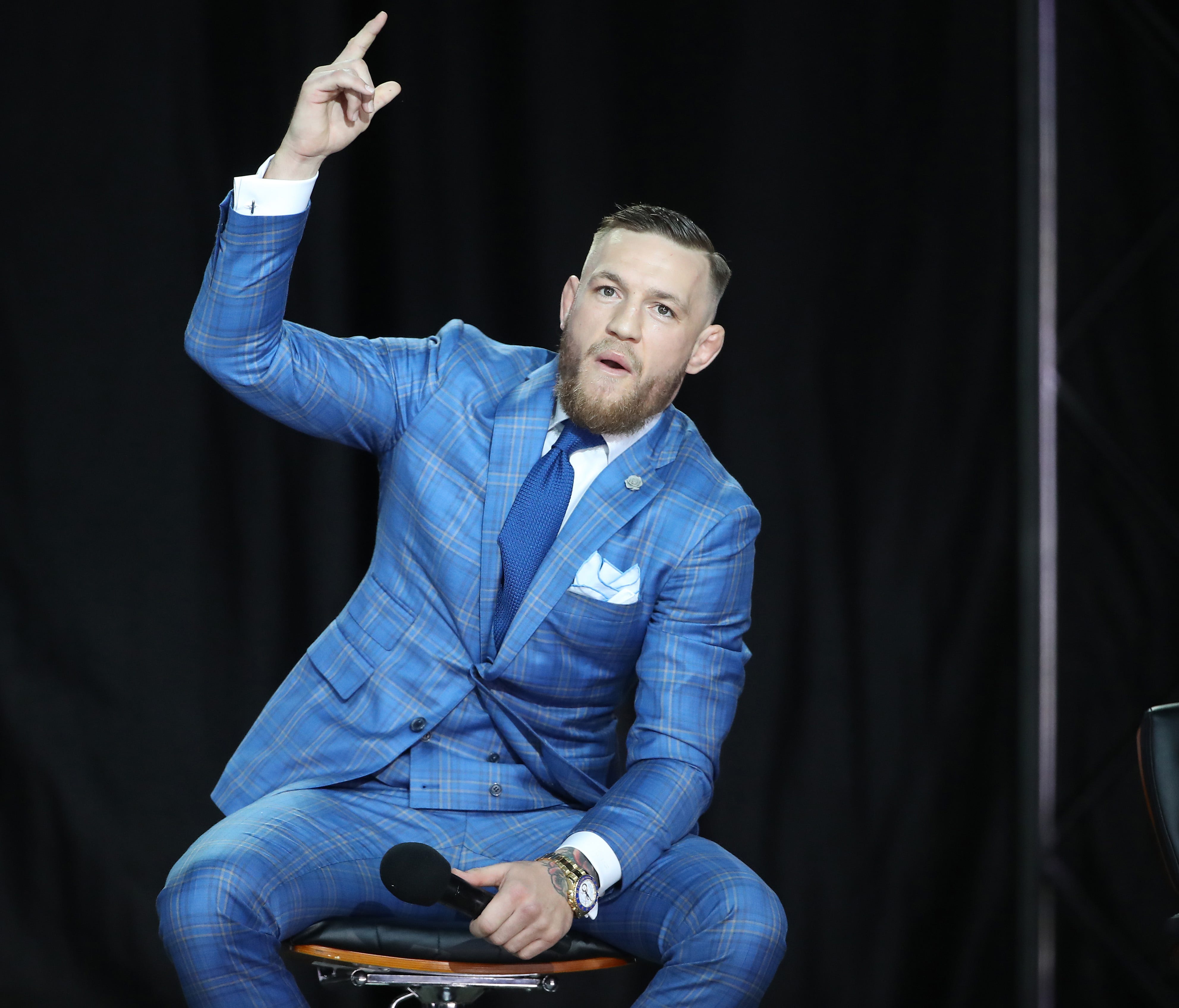Conor McGregor looks dapper in his designer suit even as he hurls insults at Floyd Mayweather.