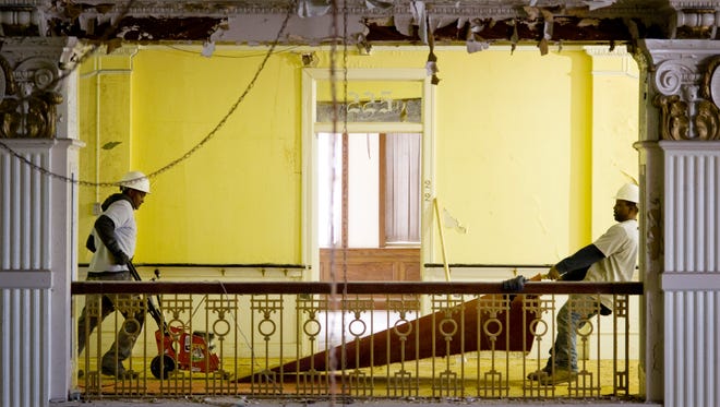 The Kunkel Group employees Tom Dayne (left) and Jerry Walsh remove carpeting on the second floor of the old Hotel McCurdy Wednesday afternoon, Jan. 26, 2016. Renovations are nearing completion.
