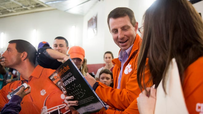 Clemson football coach Dabo Swinney is mobbed by fans during while visiting Oak Ridge High School to watch Clemson commitment Tee Higgins on Tuesday.
