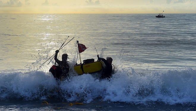 Derek Swor (left) and Jayson Clayton, both of Melbourne Beach, make their way into the surf with their diving gear, Wednesday, July 26, 2017, near Sexton Plaza in Vero Beach on the first day of the lobster mini-season. "The lobster seem to congregate farther south than where we live," Clayton said. Divers are permitted to take 12 lobsters per person if diving in Florida waters outside of Monroe County or Biscayne Bay National Park during the two-day mini-season. 