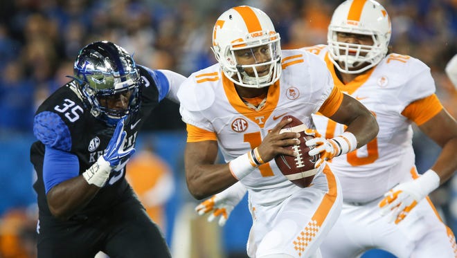 Tennessee quarterback Joshua Dobbs scrambles in front of Kentucky defensive end Denzil Ware during the first half of an NCAA college football game Saturday, Oct. 31, 2015, in Lexington, Ky. (AP Photo/David Stephenson)