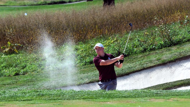 John Glenn's Dylan Van Fossen blasts out of a bunker on the par-3 13th hole on Friday during the first round of the Division II state golf tournament at Ohio State's Scarlet Course. Van Fossen, who shot 74, is just one shot back of the lead.