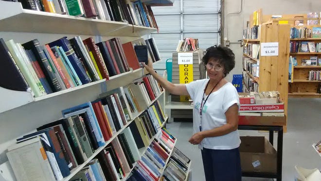 Volunteer Joanne Lupica shelves newly donated books to the shelves full of classic literature, part of the half-price sale for educators at the Friends' Book Depot.