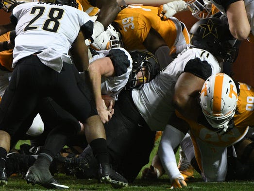 Tennessee players and Vanderbilt players pile on each