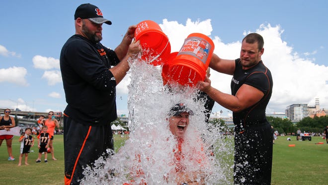 Paul Rinderknecht of Springfield Township, who was diagnosed with amyotrophic lateral sclerosis in March, takes the Ice Bucket Challenge with a little help from Bengals tackle Andrew Whitworth (left), running back Rex Burkhead and guard Kevin Zeitler (right).