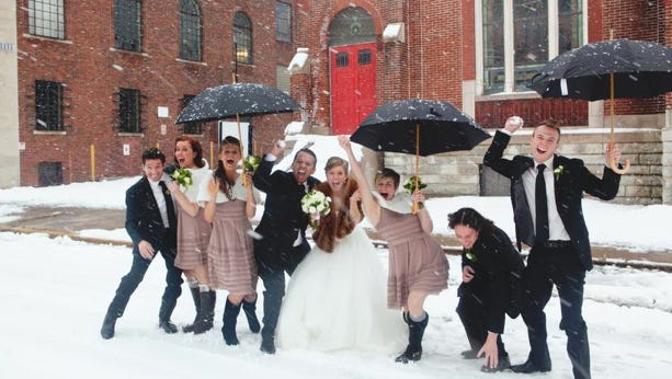 Fabian and Megan Puello celebrate and throw snowballs with their wedding party in Downtown Indianapolis after being married on Jan. 5, 2014.