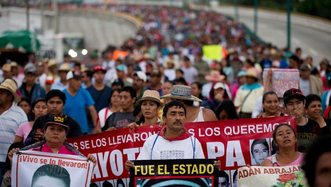 Relatives of the 43 missing Ayotzinapa teachers' college students lead a march marking the one-year anniversary of the students' disappearances in Chilpancingo, Mexico, Saturday, Sept. 26, 2015.