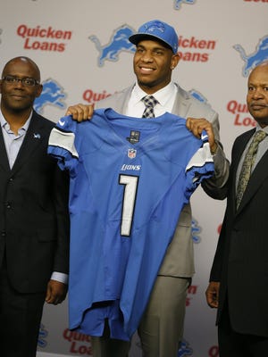 Detroit Lions general manager Martin Mayhew, left, and head coach Jim Caldwell, right, pose with 2014 top draft pick Eric Ebron.