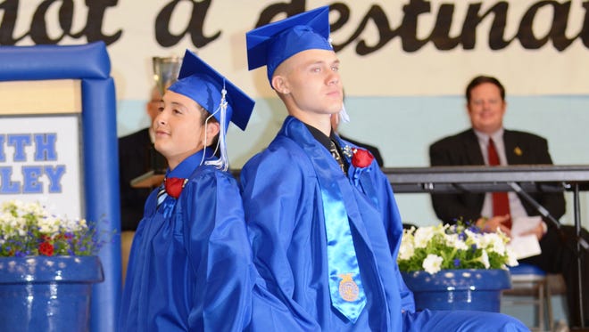 Smith Valley High School graduates Tony Gomes, left, and Ryan Rader strike a pose before they march to the back of the school’s gym at the conclusion of Friday’s commencement.