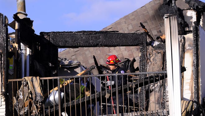 Firefighters and investigators  on the fire  scene of the Landings at Chandler Crossing apartment complex in East Lansing  Monday    10/6/2014  .    (Lansing State Journal | Rod Sanford)