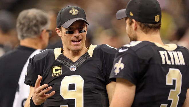 New Orleans Saints quarterback Drew Brees (9) talks to quarterback Matt Flynn (3) on the sidelines during in the second half  of their game against the Jacksonville Jaguars at the Mercedes-Benz Superdome.