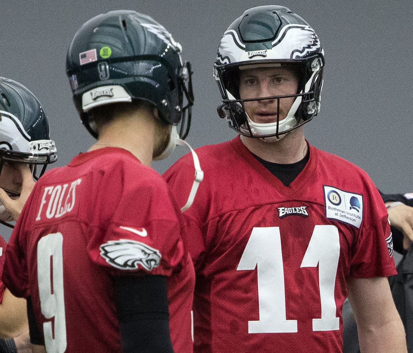 Carson Wentz talks to fellow Eagles QBs Nick Foles (9) and Nate Sudfeld (7) at a practice last month.