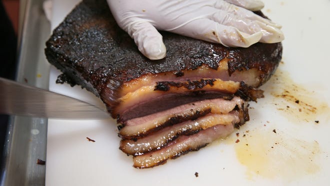 A cook slices off an order of brisket at the Texas Bar-B-Q Joint in Henrietta in 2016.