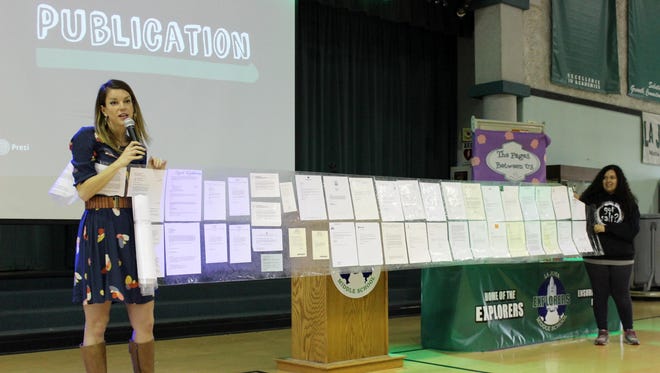 Author Lindsey Leavitt and a La Joya Middle School student hold out Leavitt’s rejection letters from book publishers and editors. The writer said it took three years to get her first book, Princess for Hire, published.
