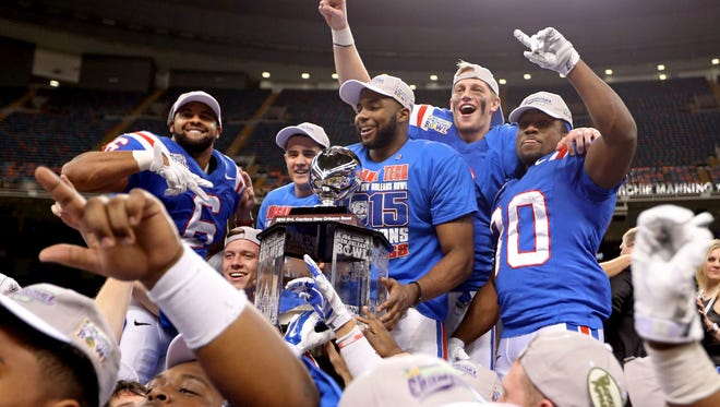 Louisiana Tech Bulldogs running back Kenneth Dixon (behind trophy) celebrates with teammates at the end of the 2015 New Orleans Bowl at the Mercedes-Benz Superdome. Louisiana Tech beat the Arkansas State Red Wolves, 47-28. Mandatory Credit: Chuck Cook-USA TODAY Sports