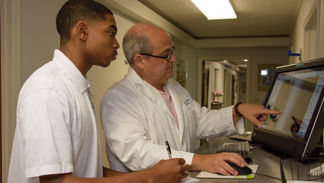 A high school student observes a family practice doctor at work during the 2016 Rural Medical Scholars summer program at Mississippi State University.
