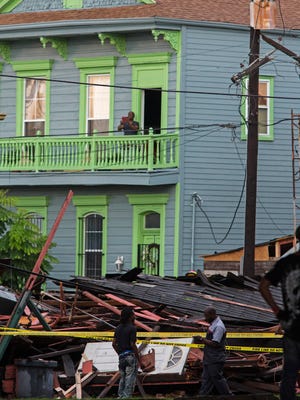Bystanders inspect a collapsed building on the corner of North Claiborne Ave. and St. Philip Street after heavy rains and powerful winds hit in New Orleans, La., Thursday, Aug. 4, 2016. A brief but intense storm pummeled New Orleans on Thursday afternoon, toppling trees and power lines and collapsing at least two abandoned houses. (AP Photo/Max Becherer)