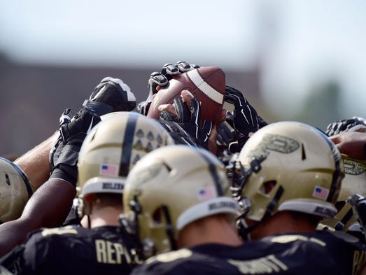 Sep 27, 2014; West Lafayette, IN, USA; The Purdue Boilermakers players raise their hands in a huddle to touch a game ball prior to their game against the Iowa Hawkeyes at Ross Ade Stadium. Mandatory Credit: Marc Lebryk-USA TODAY Sports