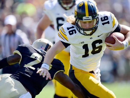 Sep 27, 2014; West Lafayette, IN, USA; Iowa Hawkeyes quarterback C.J. Beathard (16) avoids being tackled by Purdue Boilermakers cornerback Antoine Lewis (23) during the first half of the game at Ross Ade Stadium. Mandatory Credit: Marc Lebryk-USA TODAY Sports