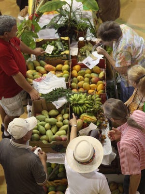 Attendees sift through fruit for sale at the Taste of Lee at the First Baptist Church in Downtown Fort Myers.